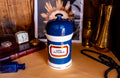 Antique apothecary blue and white jar with a label that says Ung: Althaea. The label is surrounded by gold foil. The white jar has a blue porcelain lid.