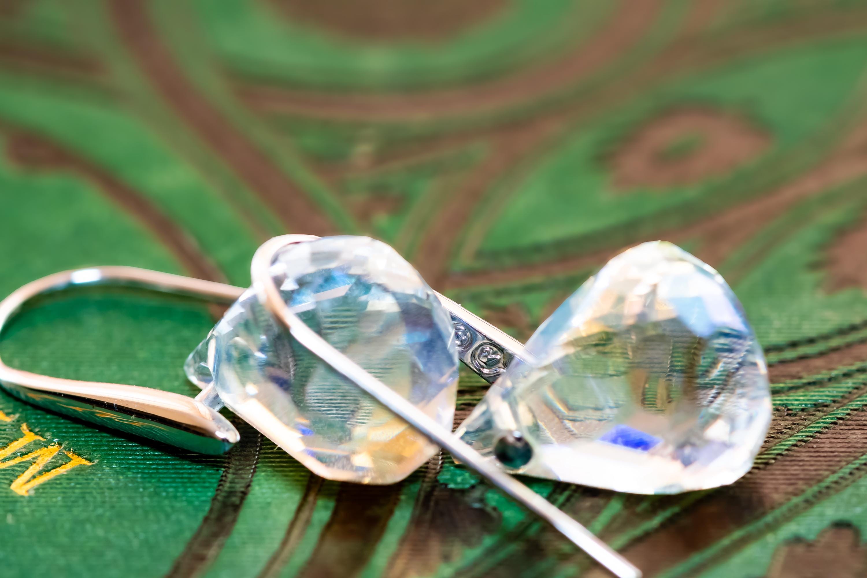 Vintage silver-tone Swarovski earrings, resting on a green antique book.