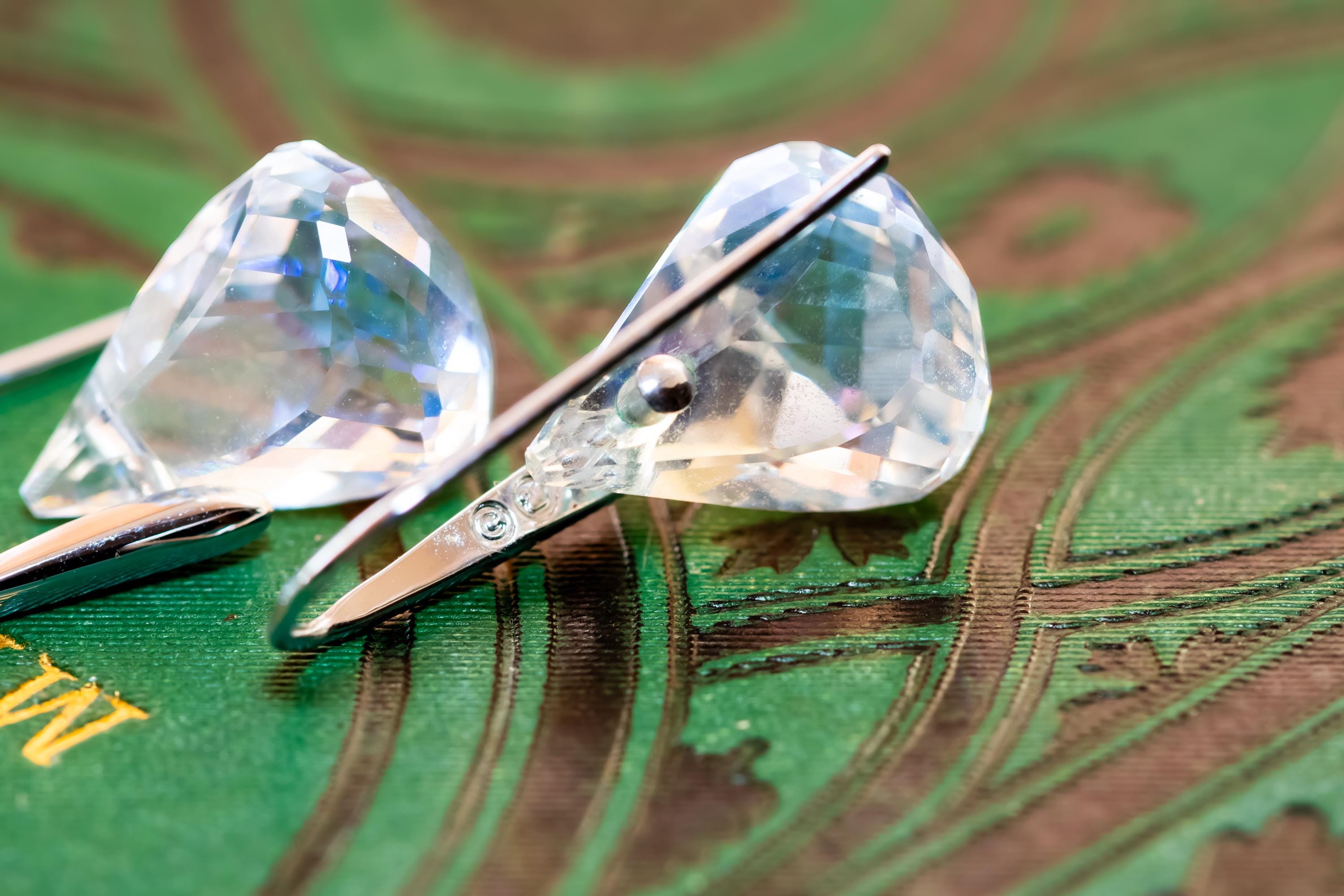 Vintage silver-tone Swarovski earrings, resting on a green antique book.