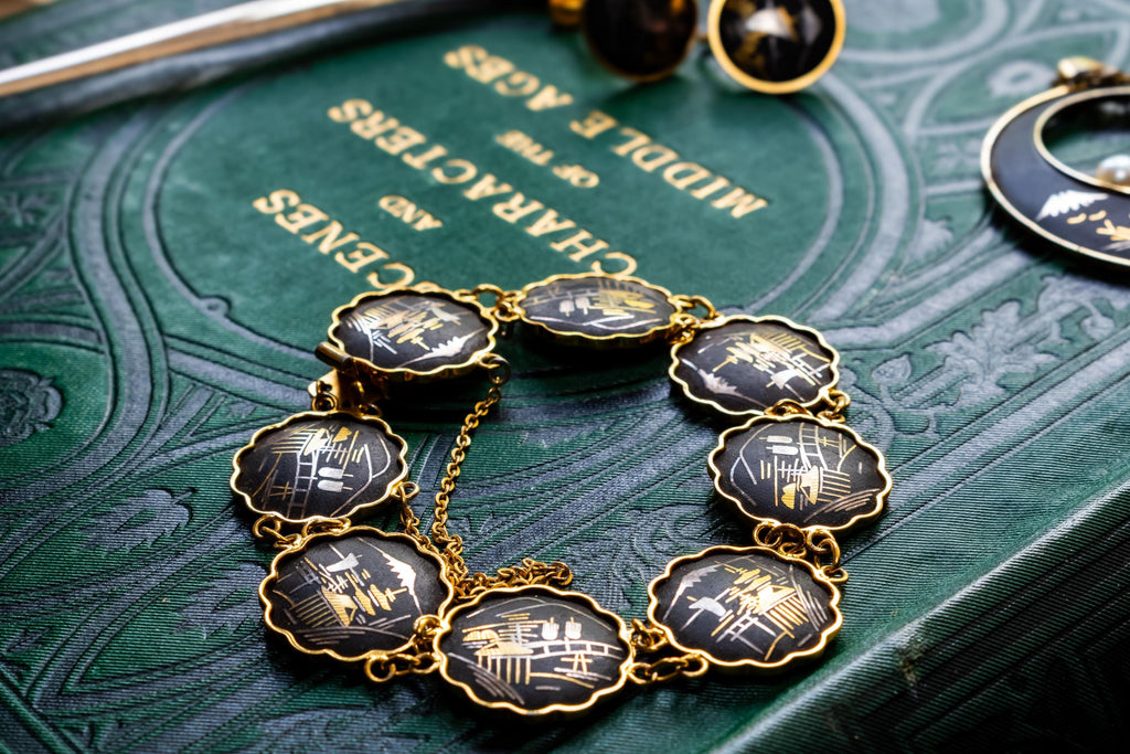 Vintage Amita Japanese damascene jewelry set including a necklace, bracelet, and earrings featuring black backgrounds with 24K gold inlay landscape scenes.
