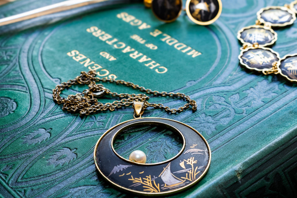 Vintage Amita Japanese damascene jewelry set including a necklace, bracelet, and earrings featuring black backgrounds with 24K gold inlay landscape scenes.