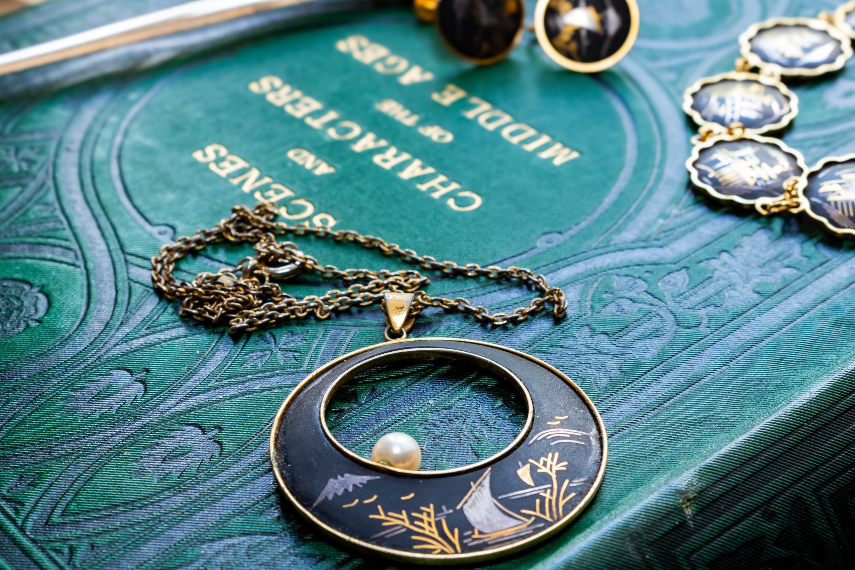 Vintage Amita Japanese damascene jewelry set including a necklace, bracelet, and earrings featuring black backgrounds with 24K gold inlay landscape scenes.