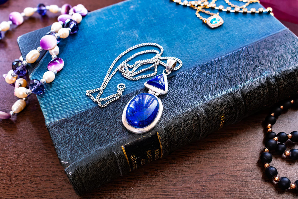 Heavy vintage sterling silver necklace featuring a large, deep blue lapis lazuli cabochon pendant with a secondary triangular lapis stone above it.