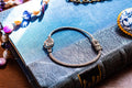 Vintage 800 silver woven bracelet featuring a central apple charm detailed with sparkling pave crystals, displayed on a blue antique text.