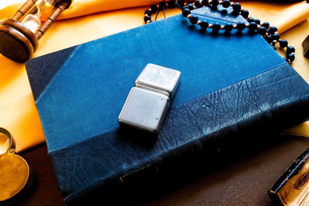 Vintage 2000 Birmingham silver square pill box featuring a smooth finish and a millennium stamp, resting on a blue antique book.