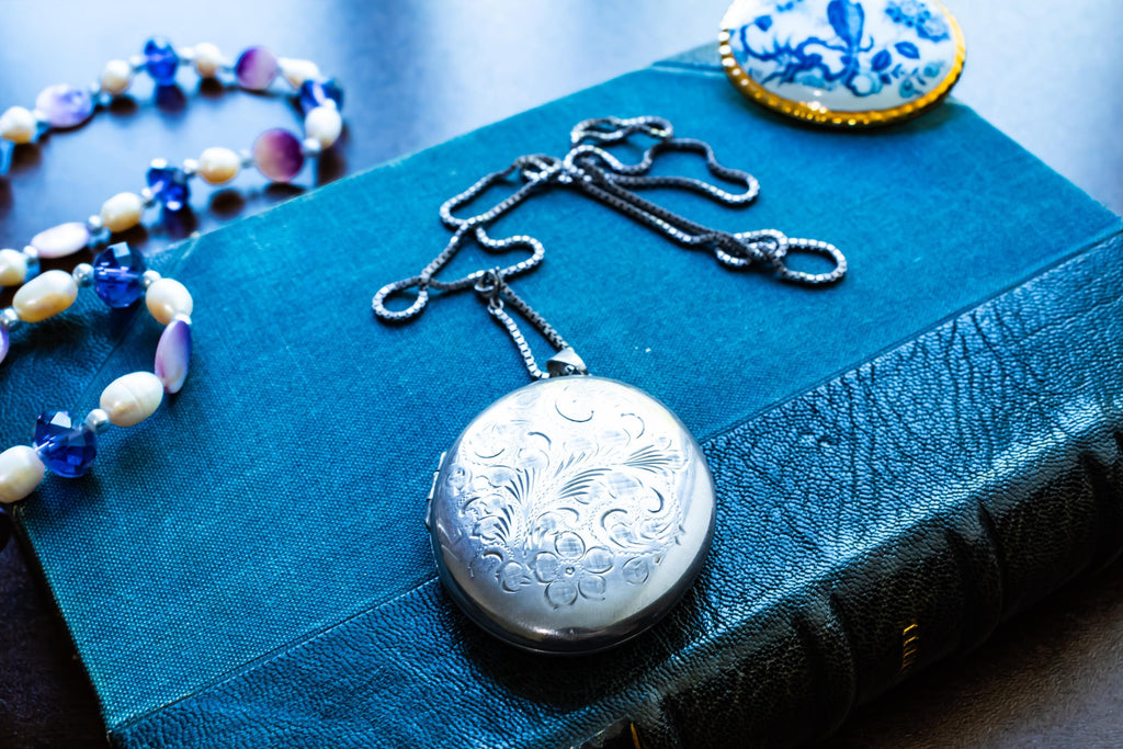 Large vintage sterling silver locket with a heavy box chain, featuring beautiful floral and scrollwork engraving on the front.