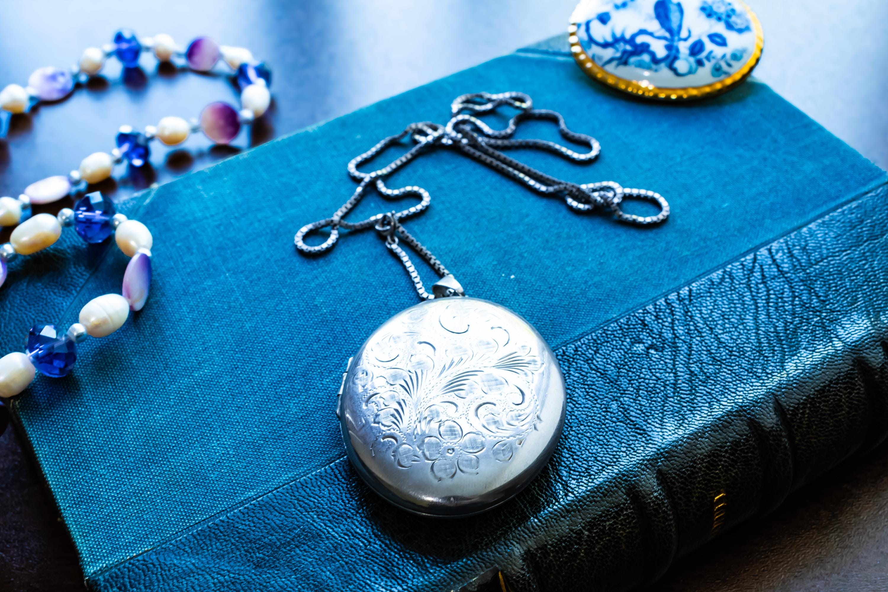 Large vintage sterling silver locket with a heavy box chain, featuring beautiful floral and scrollwork engraving on the front.