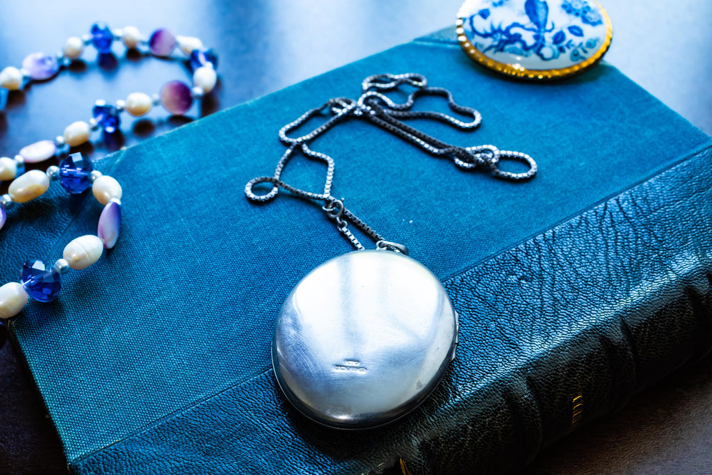 Large vintage sterling silver locket with a heavy box chain, featuring beautiful floral and scrollwork engraving on the front.