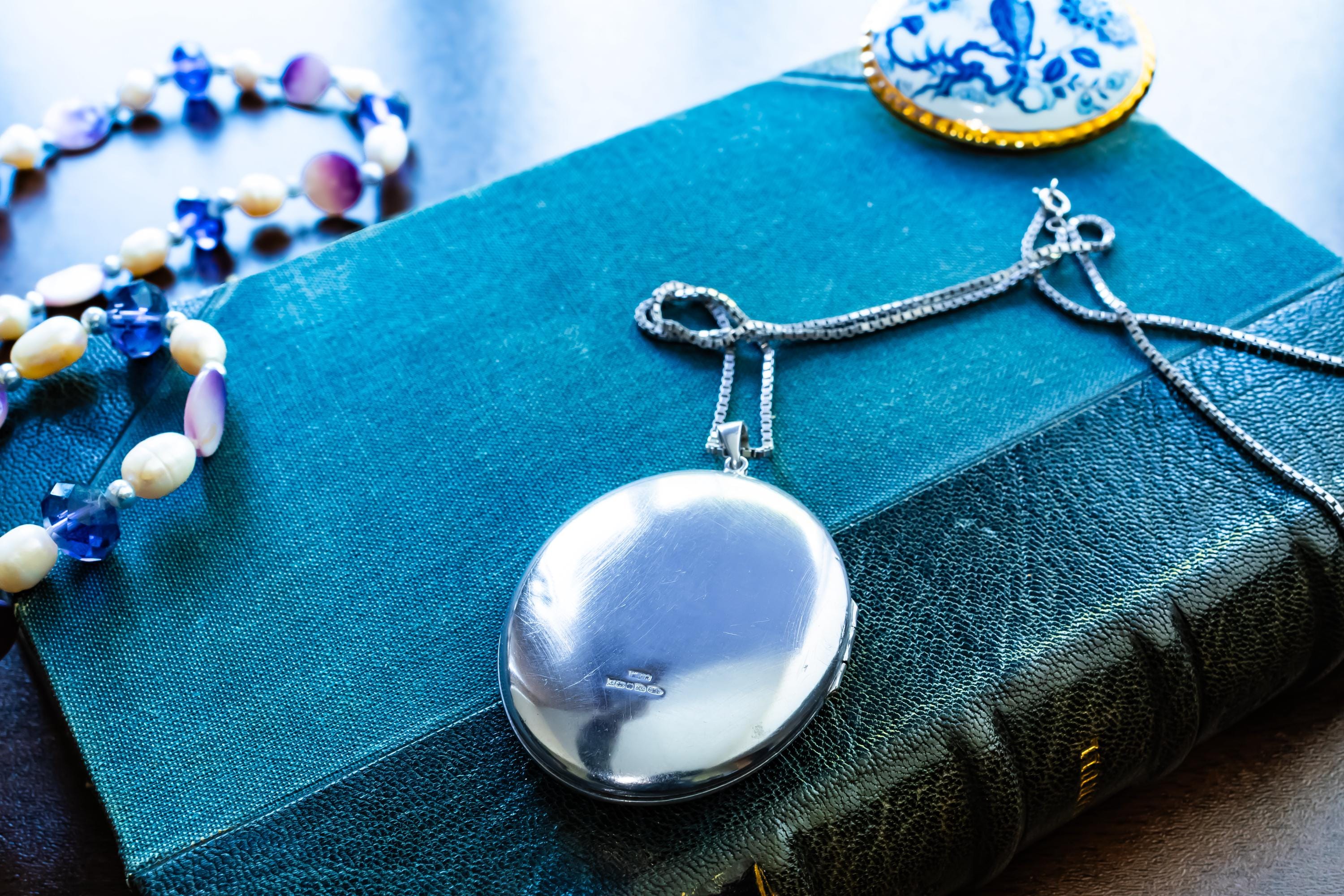 Large vintage sterling silver locket with a heavy box chain, featuring beautiful floral and scrollwork engraving on the front.