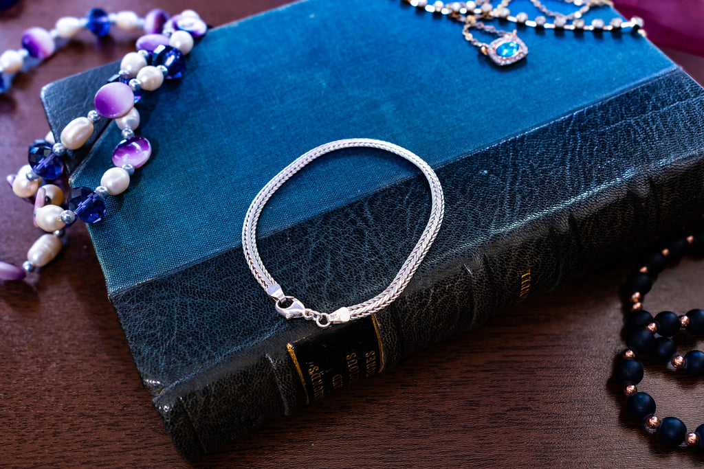 Vintage 925 sterling silver foxtail chain bracelet by Guldfynd AB, displayed on an antique blue book.