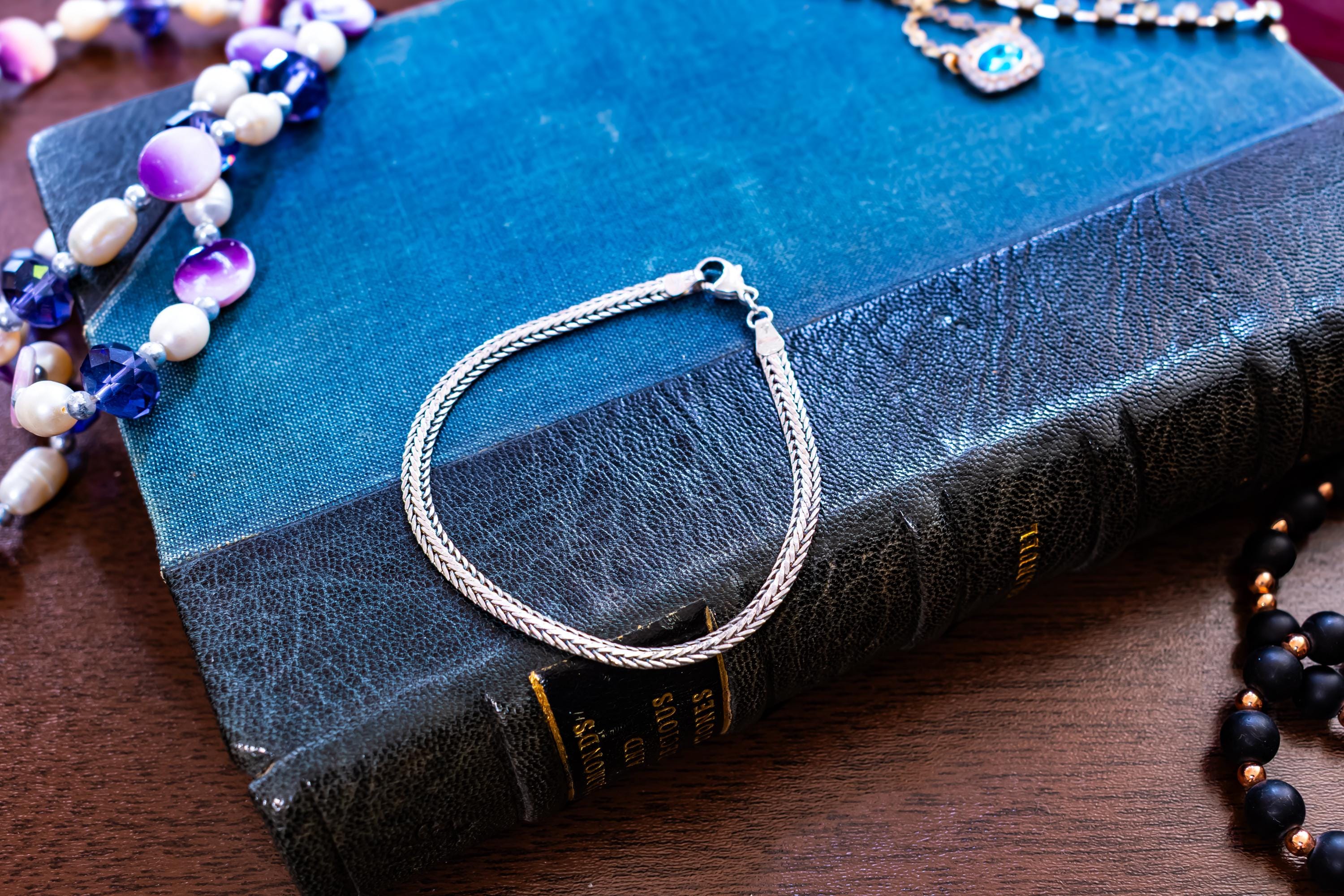 Vintage 925 sterling silver foxtail chain bracelet by Guldfynd AB, displayed on an antique blue book.